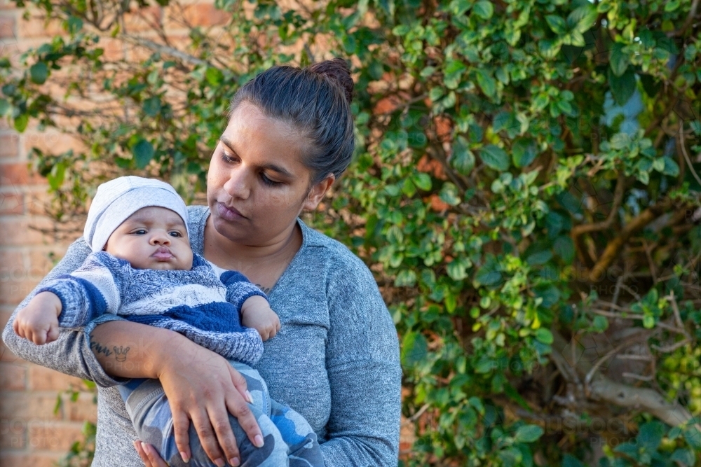 Young mother holding her baby outside - Australian Stock Image