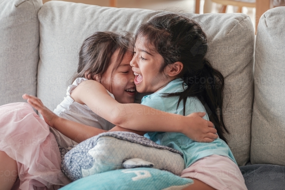 Young multicultural girls having a hug - Australian Stock Image