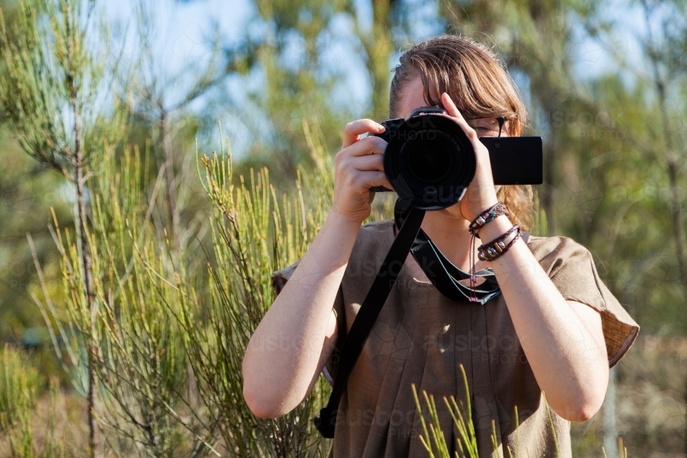 Young nature photographer standing among bushes - Australian Stock Image