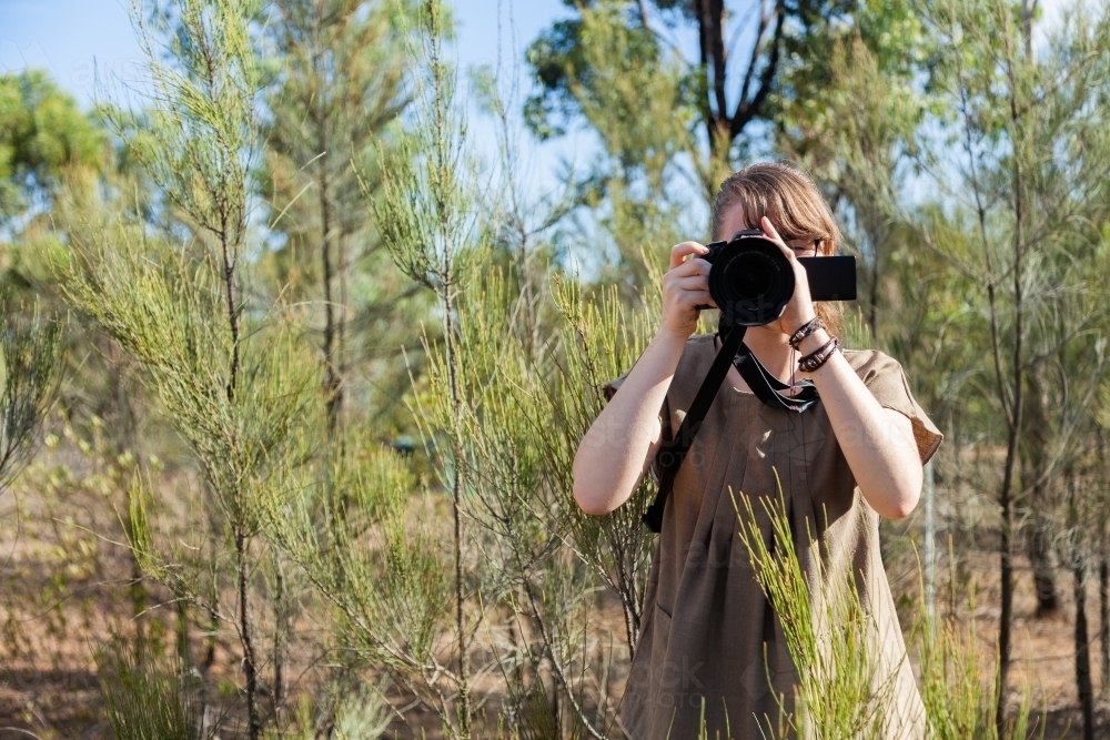 Young nature photographer standing among bushes - Australian Stock Image