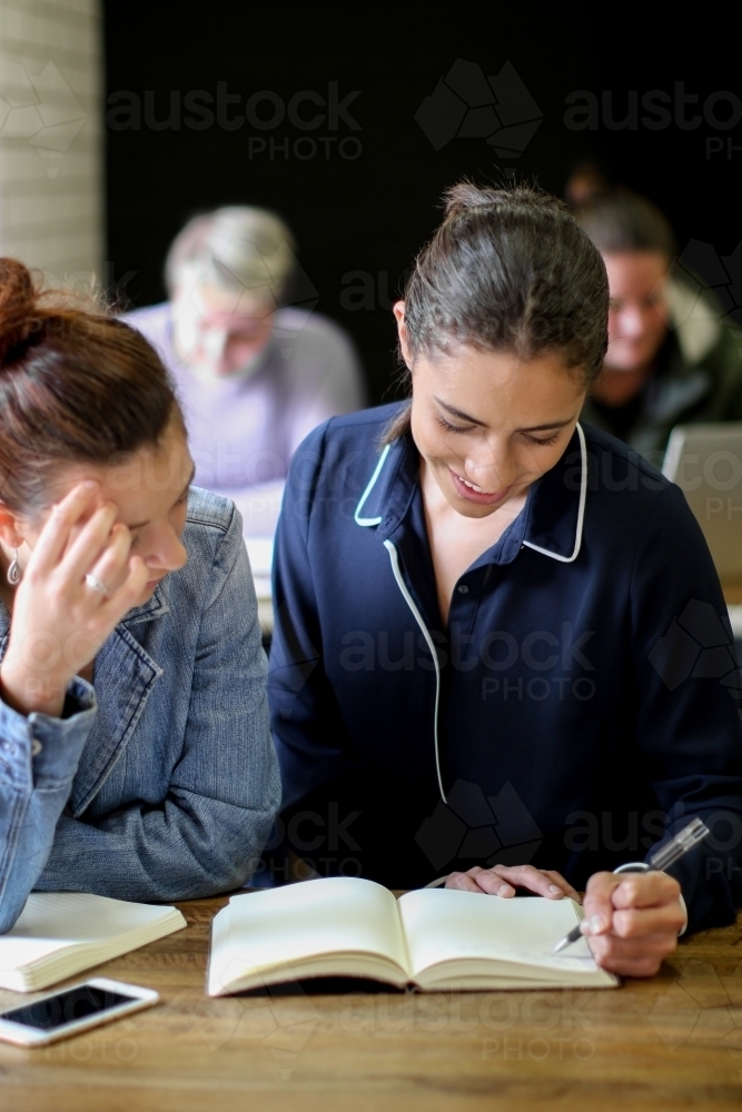 Young people sitting at a desk in a classroom - Australian Stock Image