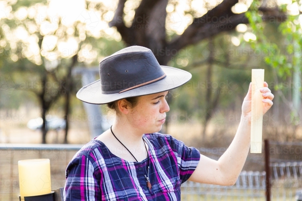 Young person measuring rain in raingauge - Australian Stock Image
