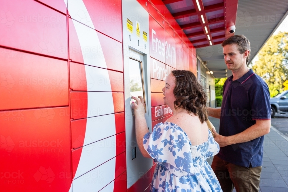 Image of Young person with a disability using post office lock box in