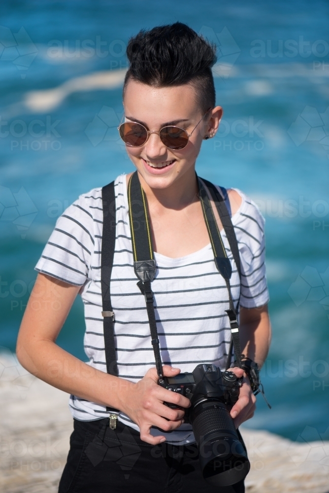 Young photographer with sunglasses smiling - Australian Stock Image