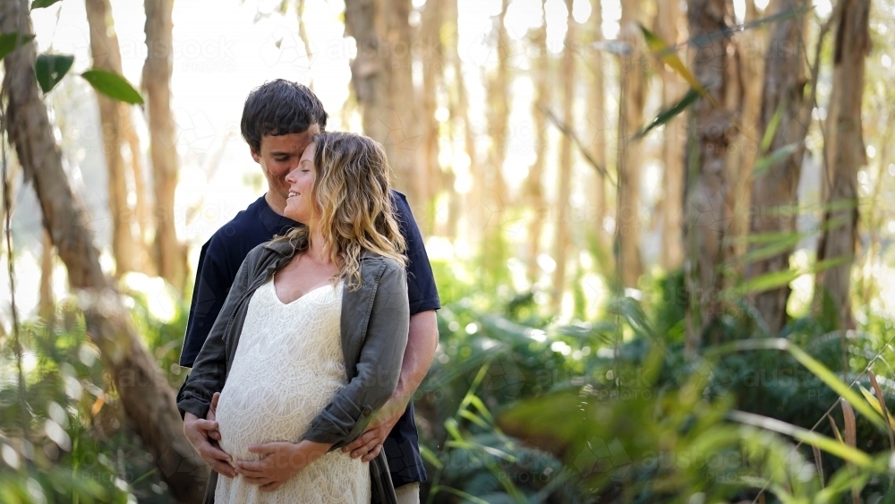 Young pregnant couple in bush setting - Australian Stock Image