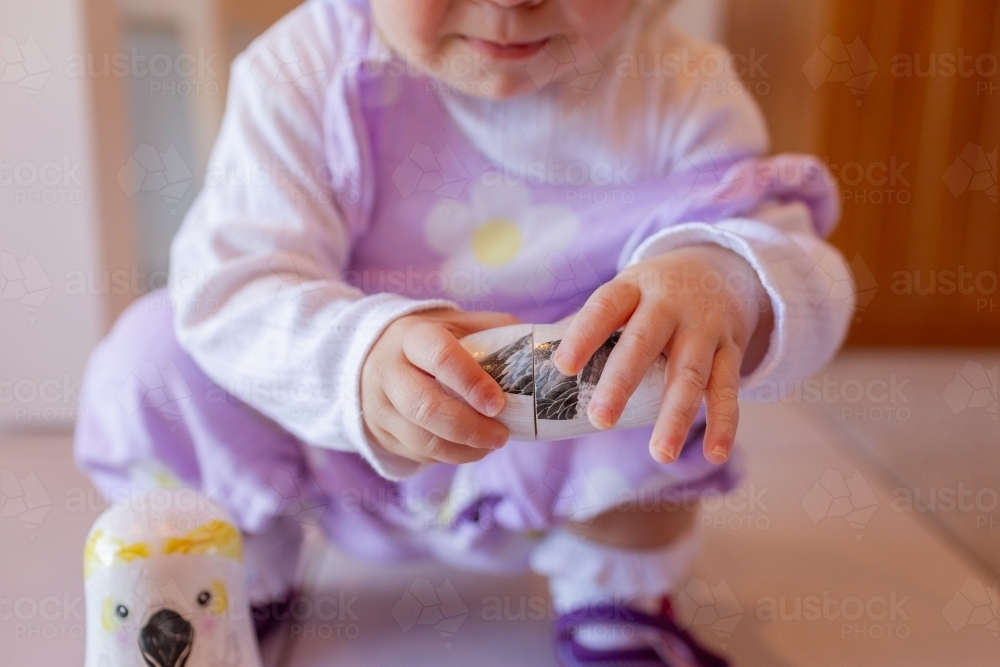 Image of Young preschool aged child playing with native australian bird nesting doll toy
