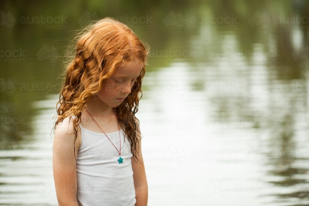 Young redhead girl by the riverside - Australian Stock Image
