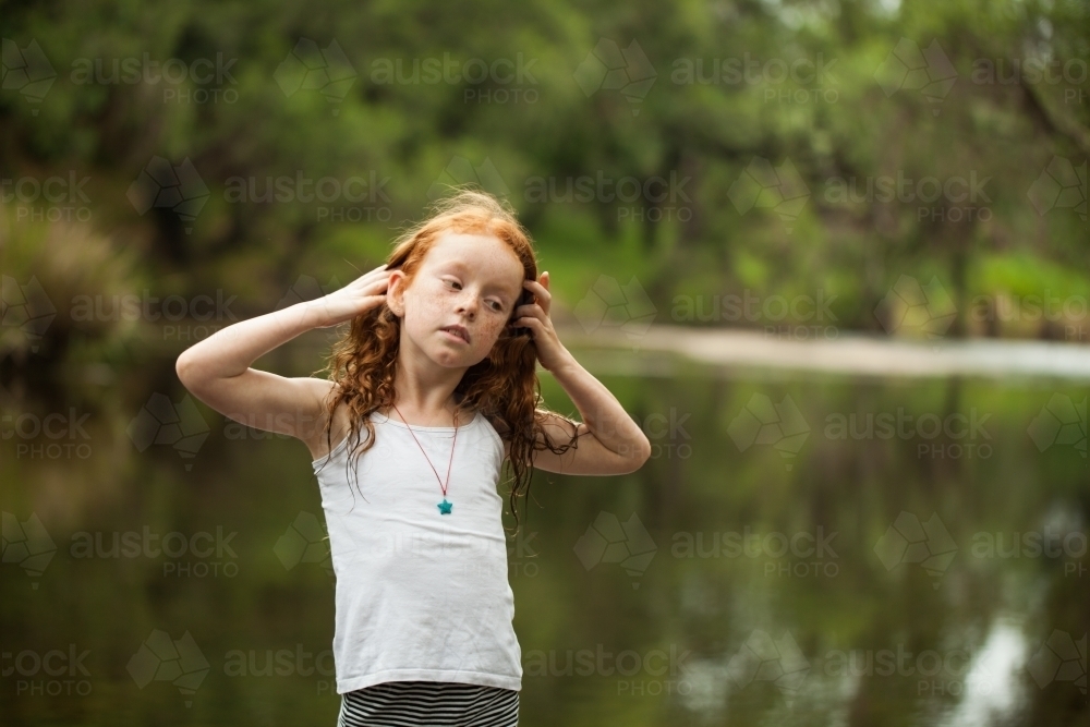 Young redheaded girl by the riverside - Australian Stock Image