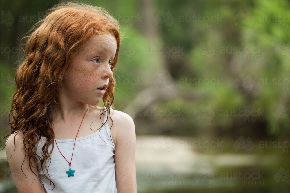 Young redheaded girl by the riverside - Australian Stock Image
