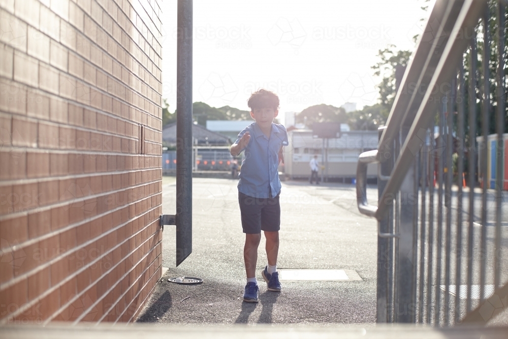 Young school boy about to jump up stairs - Australian Stock Image