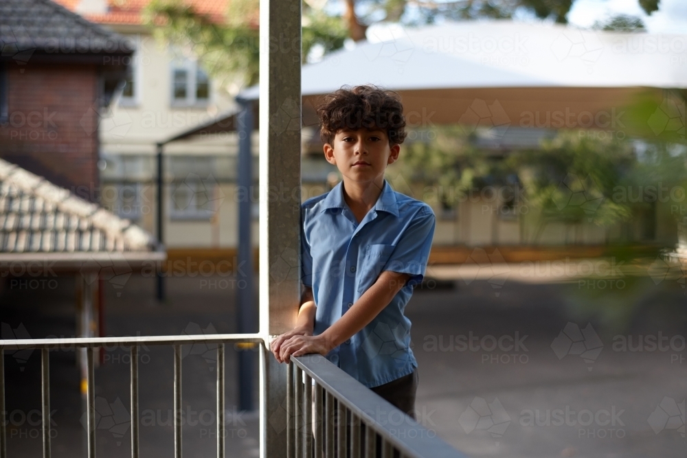 Young school boy at school holding hand rails - Australian Stock Image