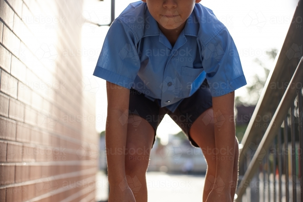 Young school boy jumping up stairs at school - Australian Stock Image