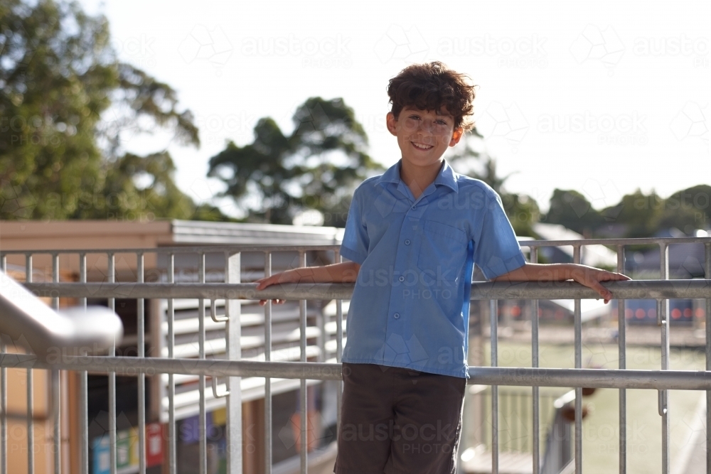 Young school boy on stairs at school smiling - Australian Stock Image