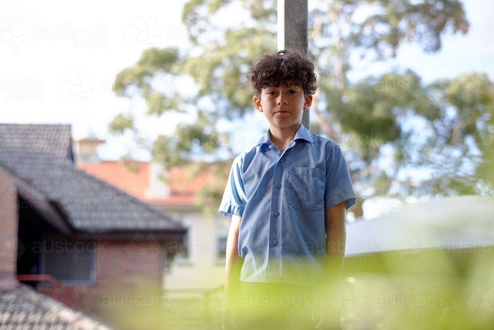Young school boy staring at camera - Australian Stock Image
