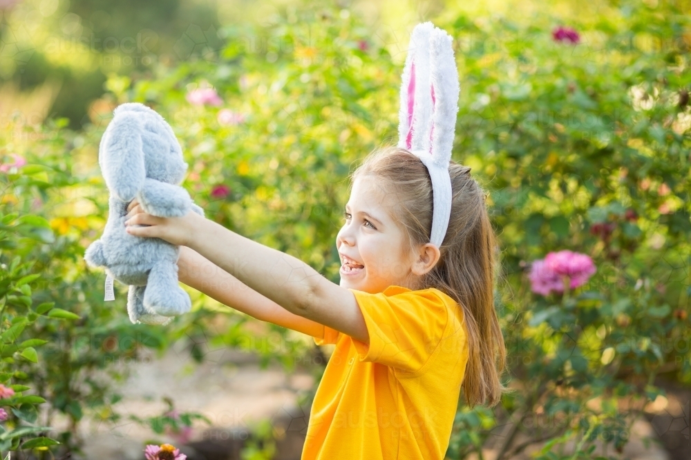 Image of Young school girl standing outside in garden at Easter time ...