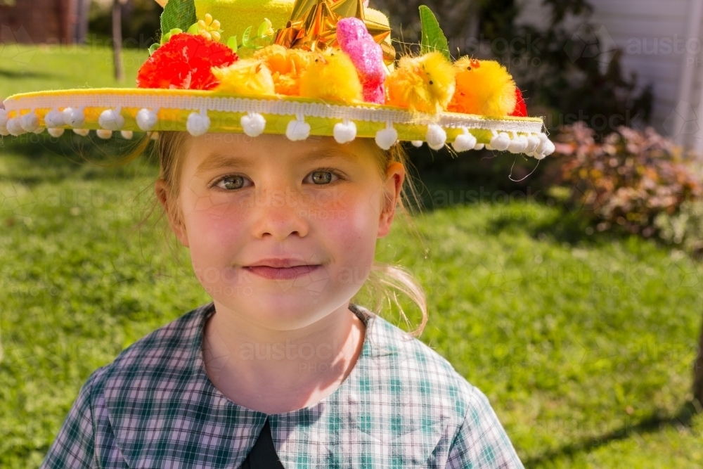 Young school girl wearing an Easter hat in the garden - Australian Stock Image
