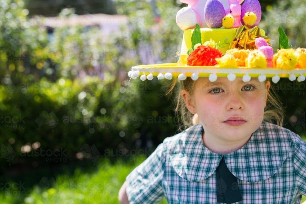 Young school girl wearing an Easter hat in the garden - Australian Stock Image