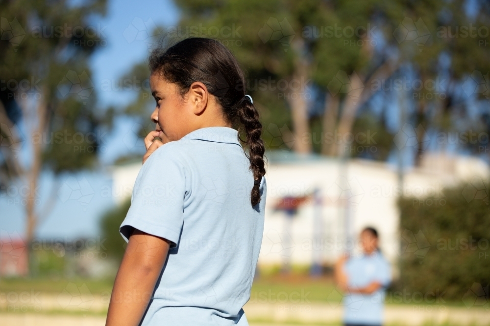 Young schoolgirl looking out of frame upper body - Australian Stock Image