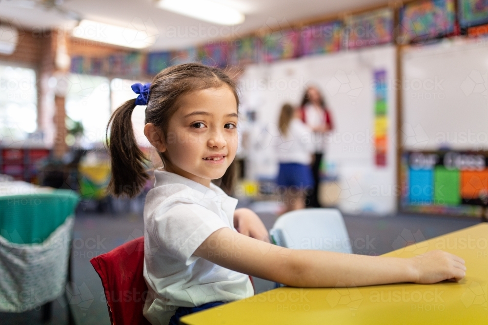 Image of Young Schoolgirl sitting behind the desk in the Classroom ...
