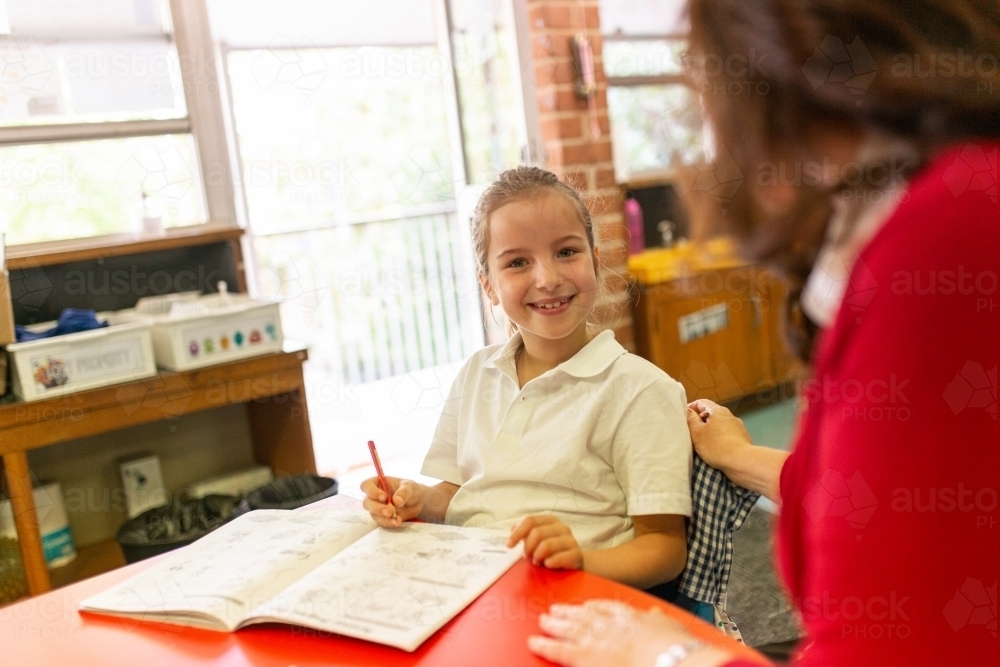 Image of Young Schoolgirl Smiling at Camera in Classroom - Austockphoto