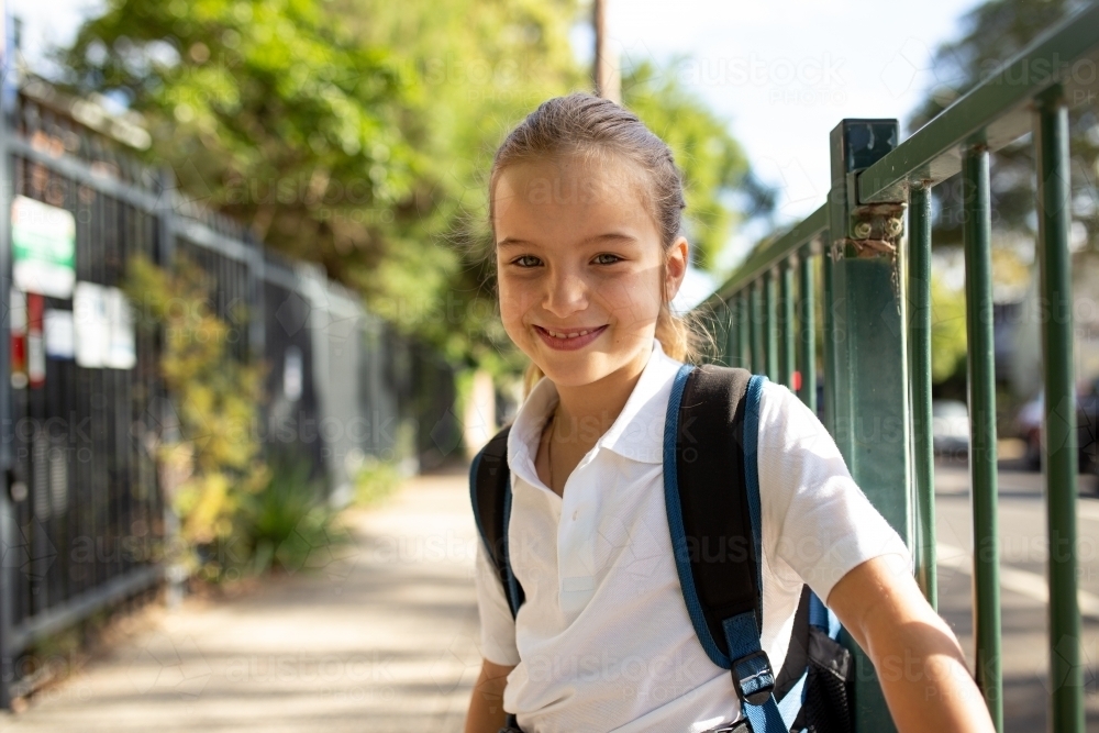 Image of Young Schoolgirl Smiling at Camera Outside - Austockphoto