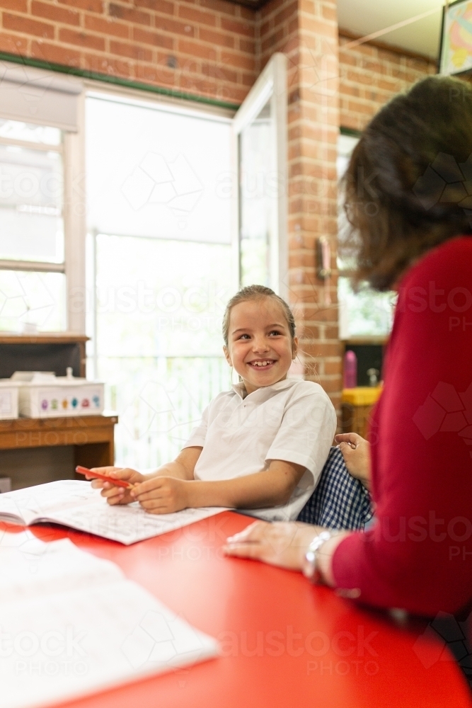 Young Schoolgirl Smiling at Teacher - Australian Stock Image