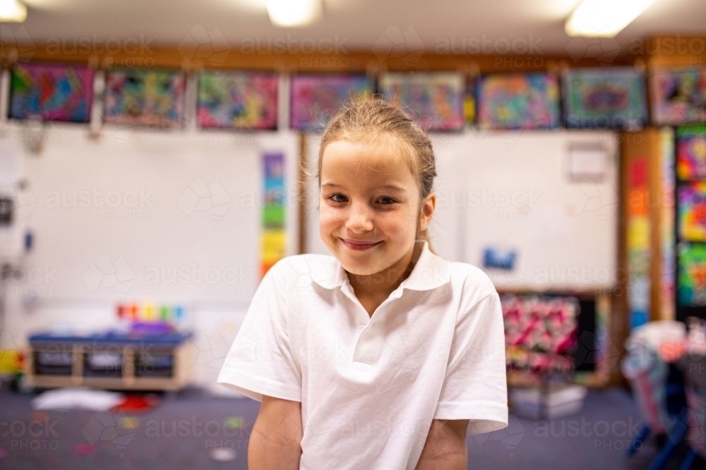 Image of Young Schoolgirl Smiling in Classroom - Austockphoto