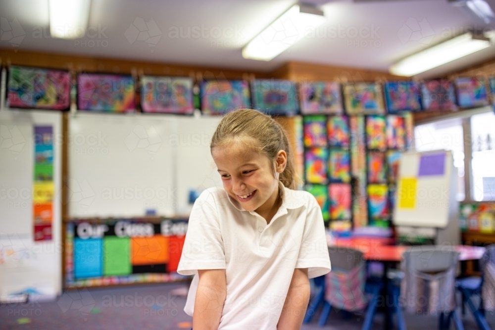 Image of Young Schoolgirl Smiling in Classroom - Austockphoto