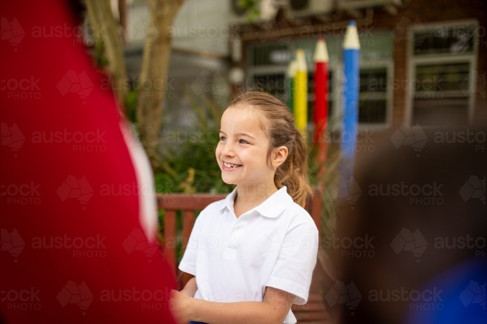 Image of Young Schoolgirl Smiling in Playground - Austockphoto