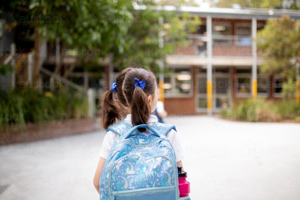 Young schoolgirl walking through playground - Australian Stock Image
