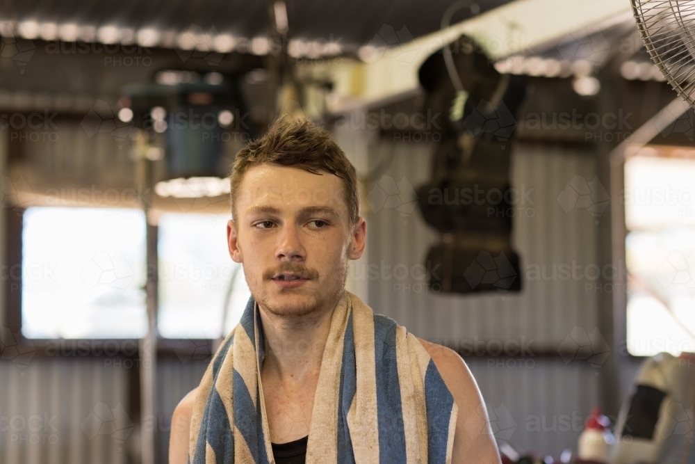 young shearer taking a break with towel around his neck - Australian Stock Image