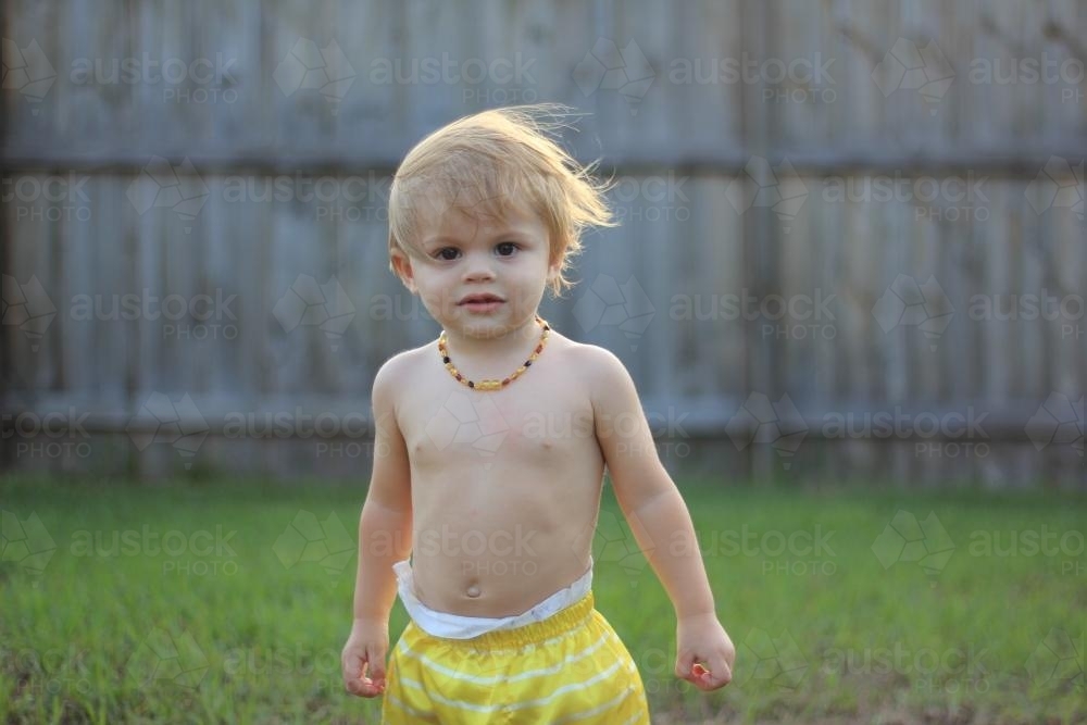 boy kid bowl hair shirtless Image of Young shirtless toddler playing in yard with wind blowing hair -  Austockphoto