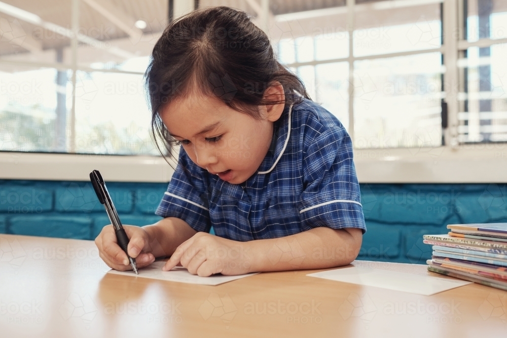 Young student girl writing in libary : Austockphoto Young student girl writing in libary - Australian Stock Image