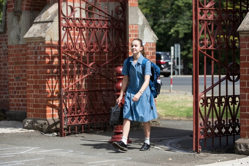 Young student walking through gates of a private girls school - Australian Stock Image