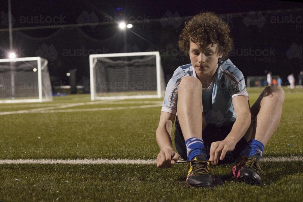 Young teen boy preparing to do evening soccer training - Australian Stock Image