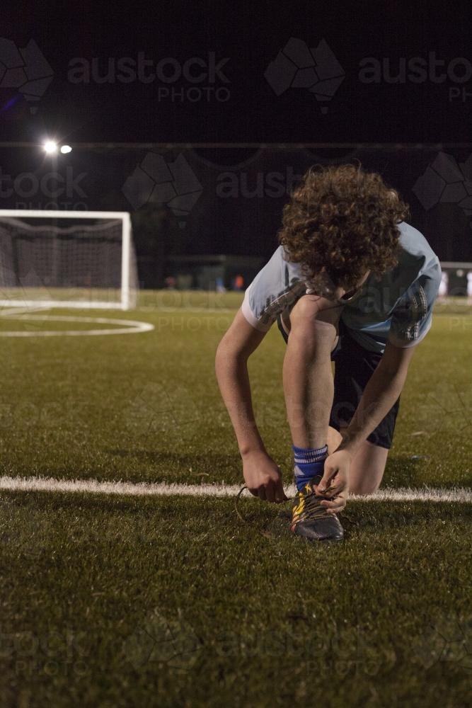 Young teen boy preparing to do evening soccer training - Australian Stock Image
