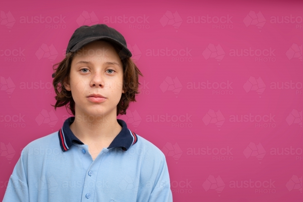 young teen school boy against magenta background - Australian Stock Image