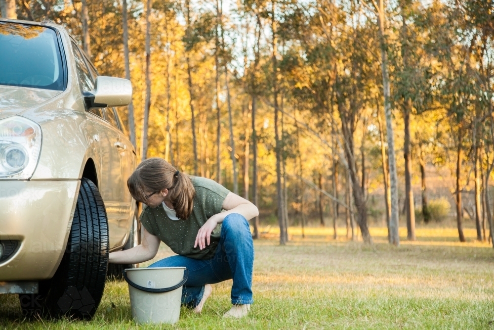 Image of Young teenage kid washing the family car