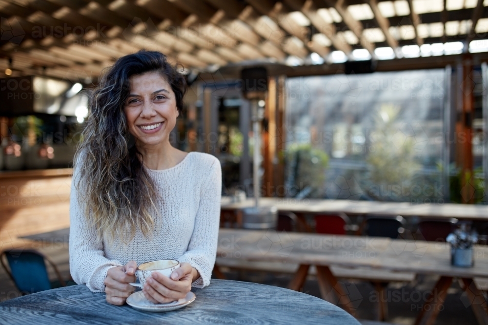 Image of Young Turkish woman drinking coffee at cafe - Austockphoto