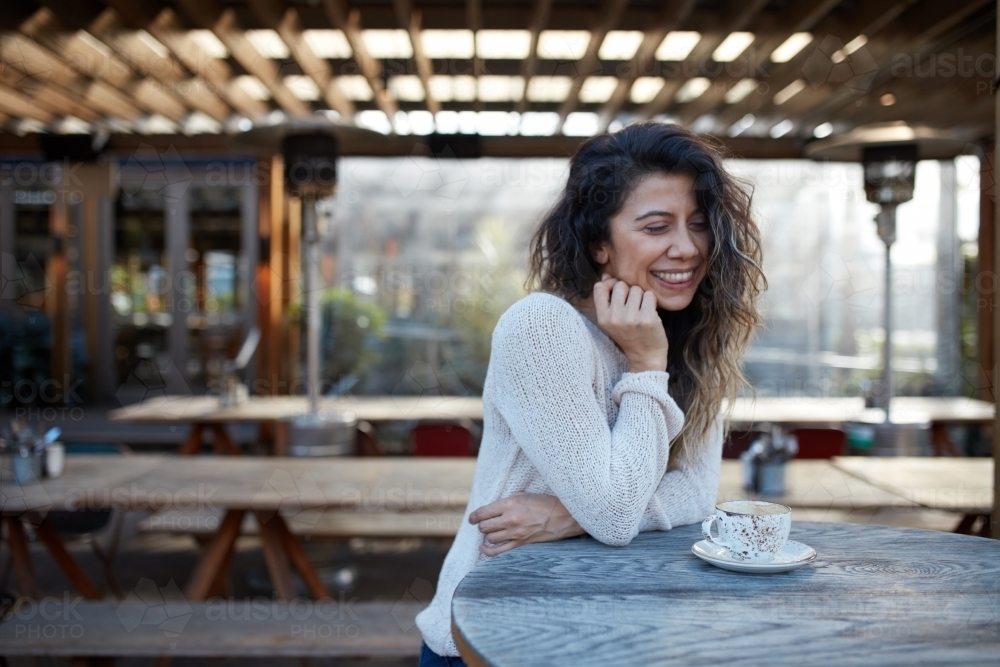 Young Turkish woman drinking coffee at cafe - Australian Stock Image