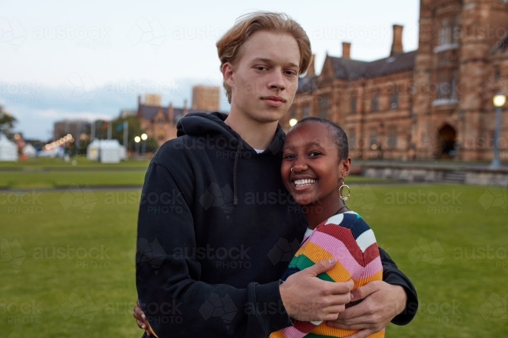 Young university couple hugging on-campus - Australian Stock Image