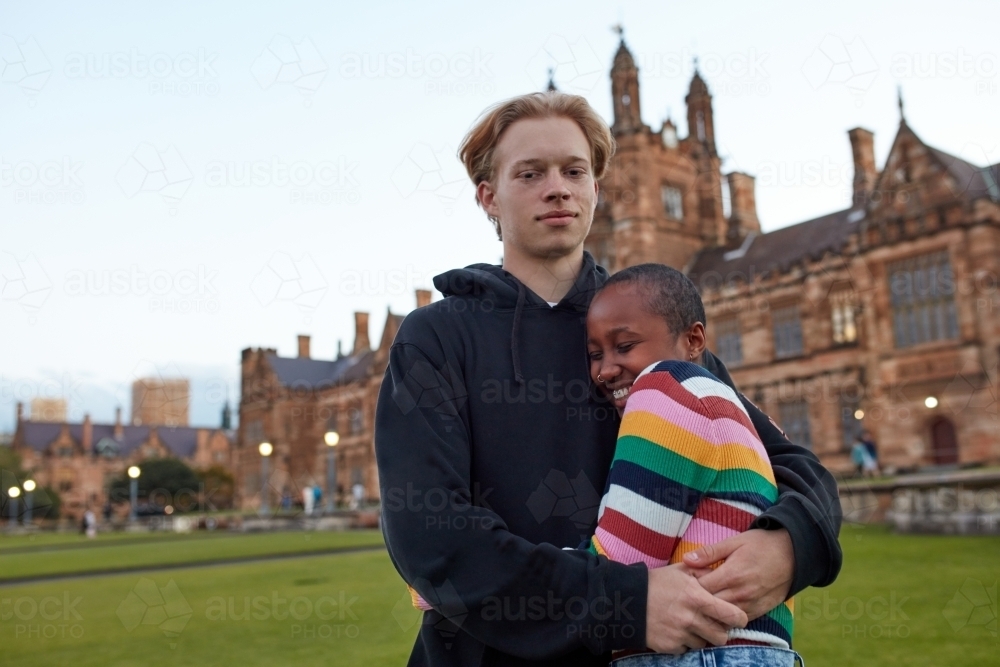 Young university couple hugging on-campus - Australian Stock Image
