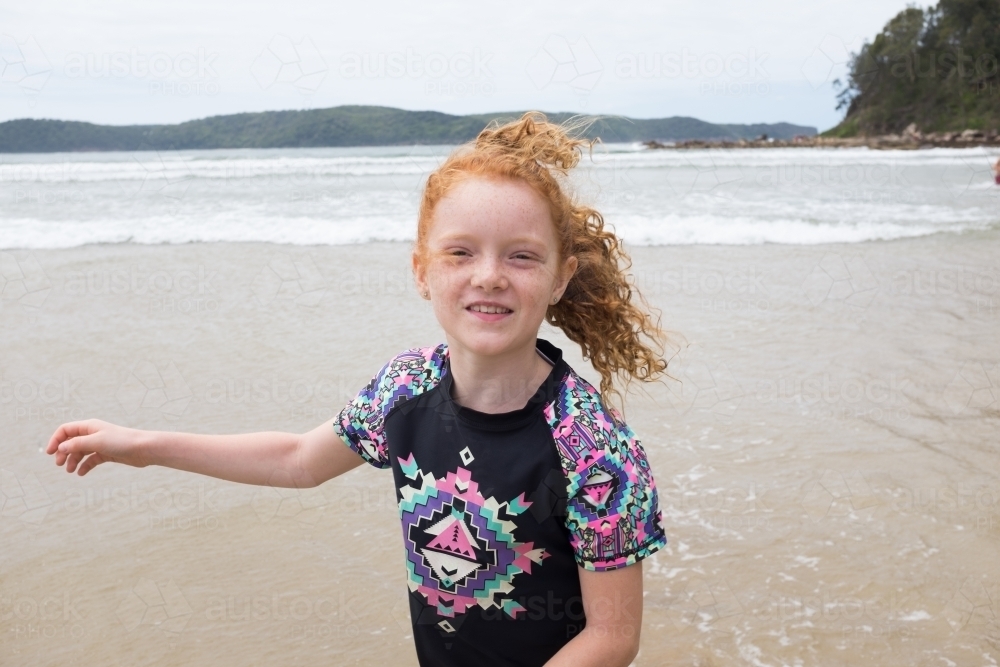Young windswept girl smiling at the beach - Australian Stock Image