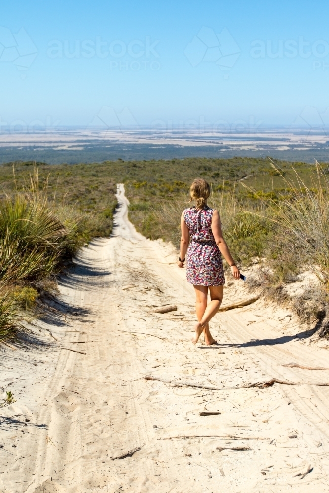 Young woman alone on sandy bush track - Australian Stock Image