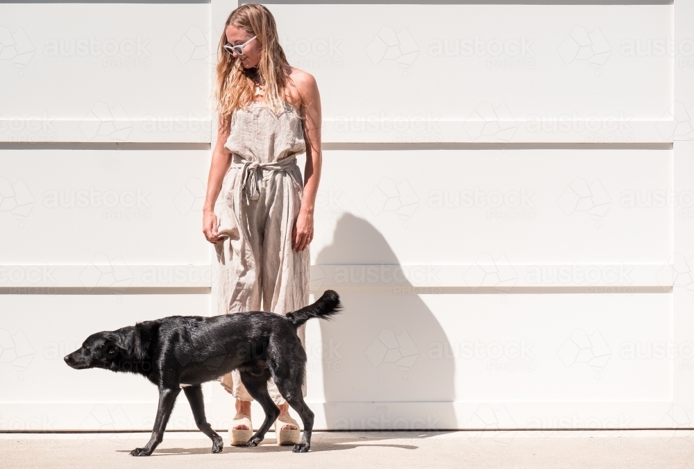 Young woman and her dog in the bright sun. - Australian Stock Image