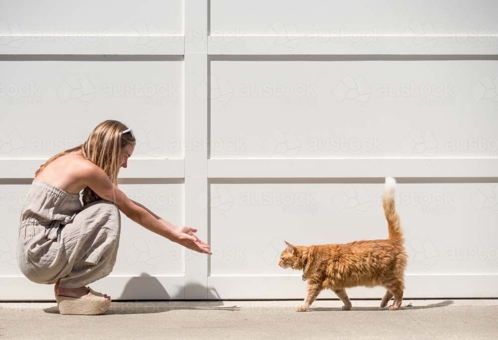 Young woman and her ginger cat in the bright sun. - Australian Stock Image