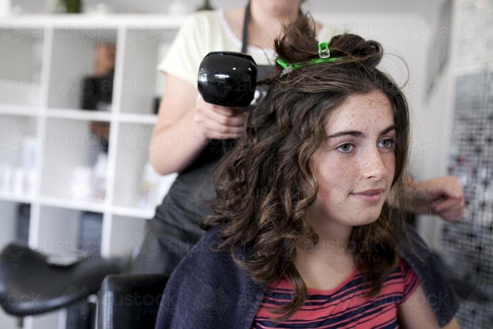 Young woman at hairdressers having hair styled - Australian Stock Image