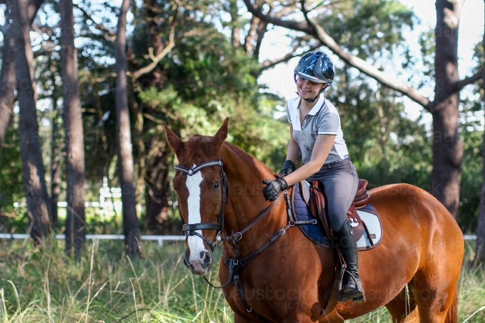 Young woman horse riding in park - Australian Stock Image