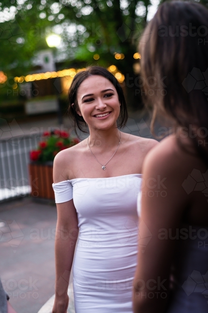 young woman in a white dress at an outdoor party - Australian Stock Image