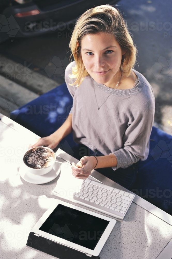 Young woman in cafe with ipad doing business or study - Australian Stock Image